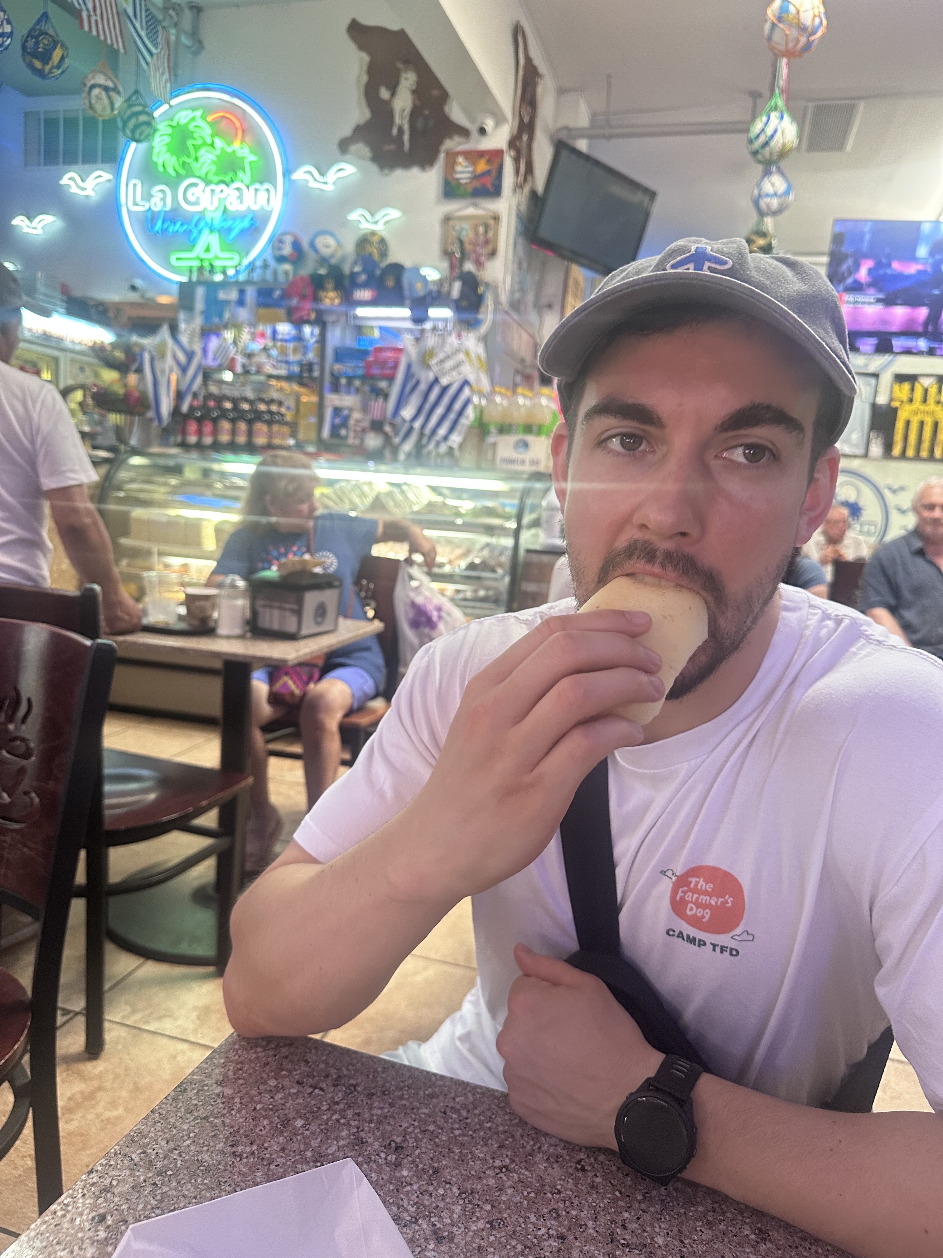 Zack eating pan de bono at La Gran Uruguaya Bakery in Jackson Heights