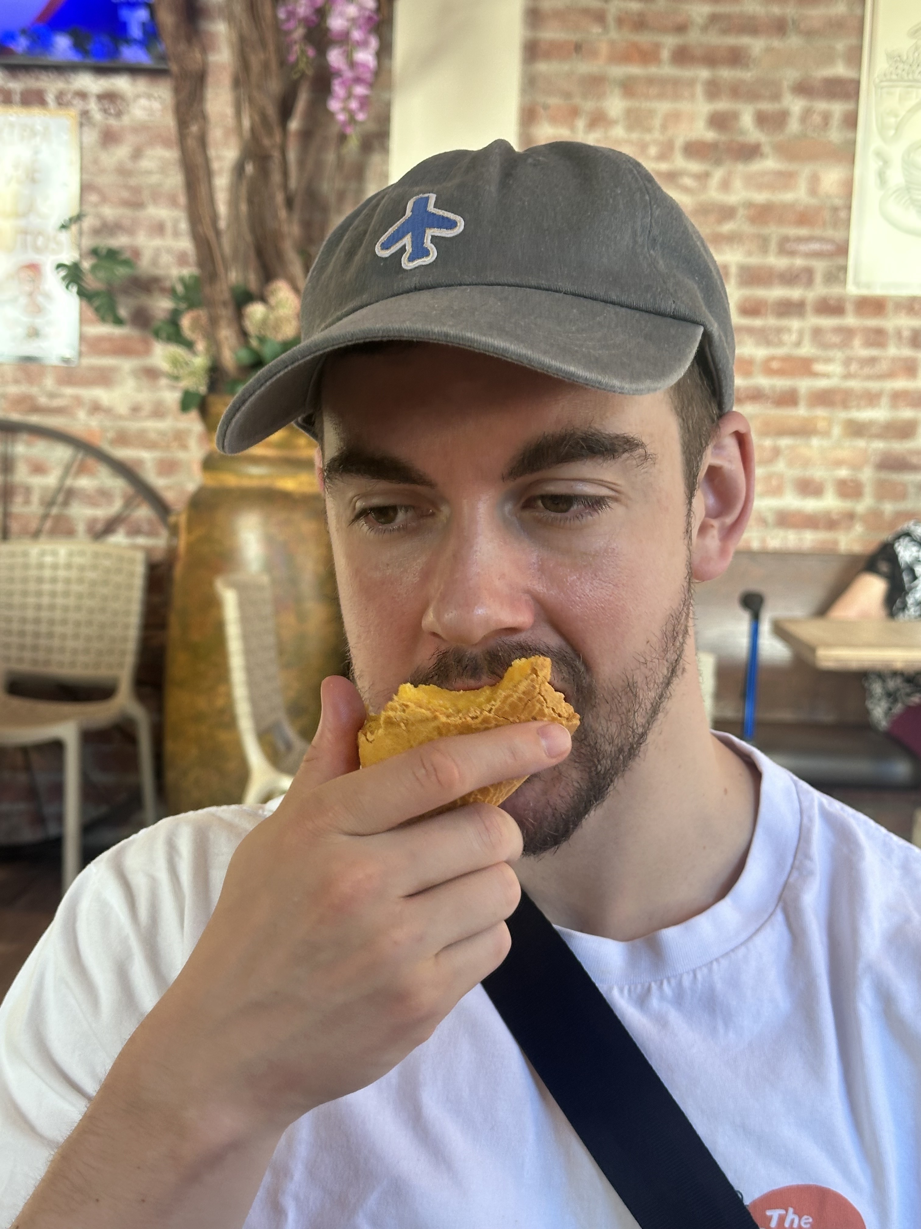 Zack eating pan de bono at Pecoshitas in Jackson Heights