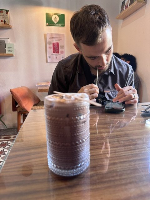Zack drinking an iced coffee at ATTA Salón Café in Puebla