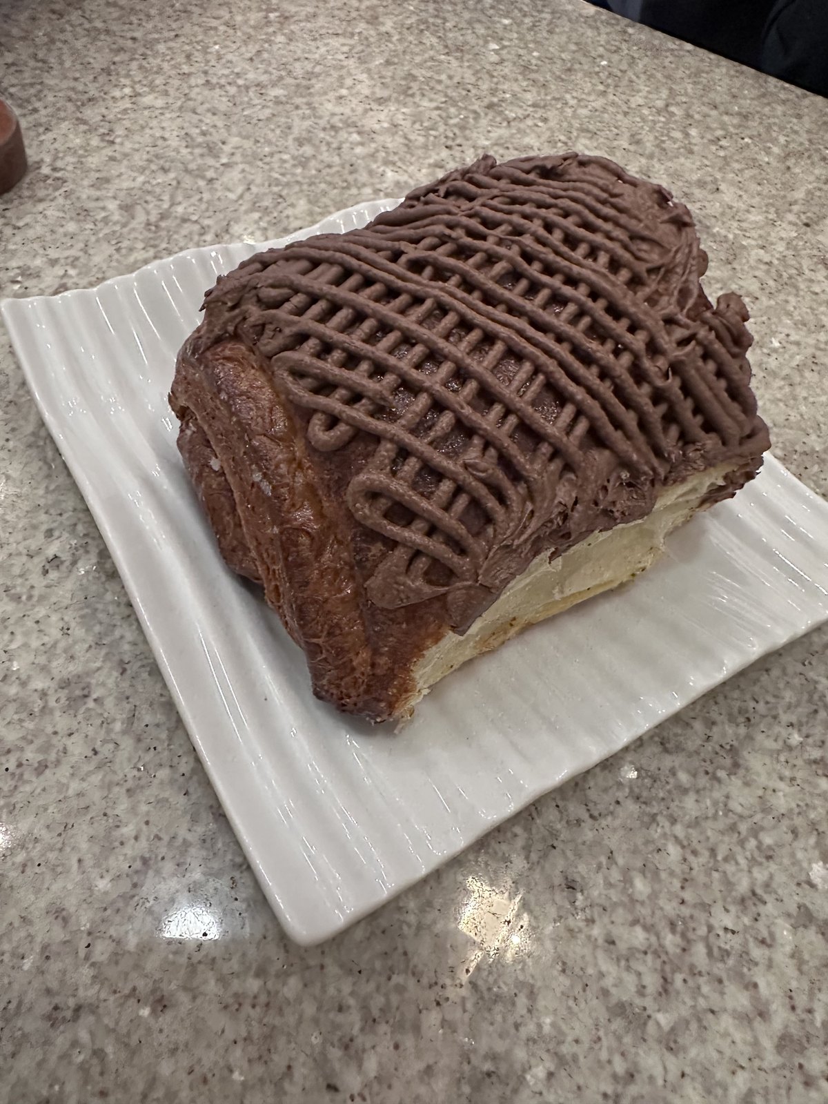 Chocolate-drizzled pastry on a white plate at Calixto Café in Puebla