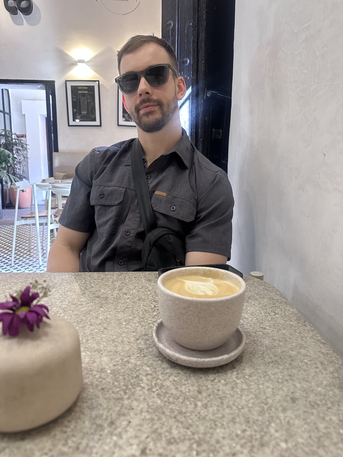 Zack sitting with a latte at Calixto Café in Puebla