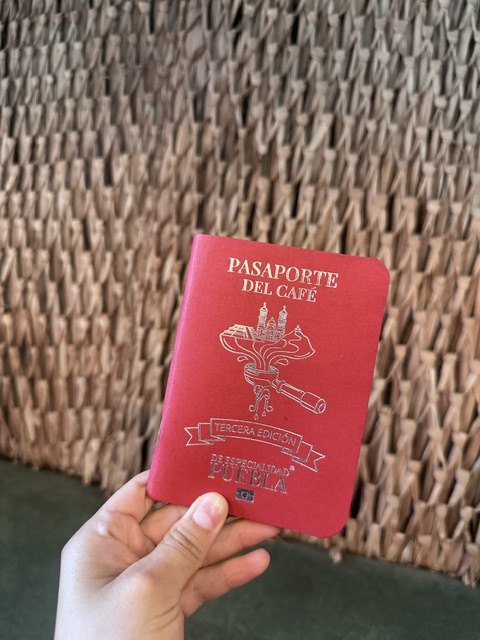 The red Pasaporte del Café de Especialidad Puebla, third edition, held in hand